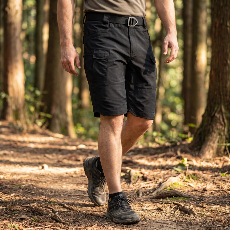 Hiker on a forest trail wearing the black TactixGuard Pro tactical shorts with D-ring belt